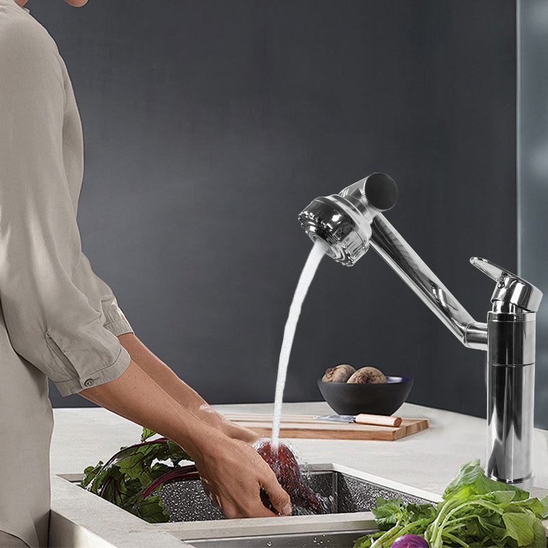 "A modern 1080-degree rotating faucet aerator installed on a stainless steel kitchen sink, with water flowing from the extended nozzle. The aerator features a chrome-plated design, a flexible multi-angle rotation,